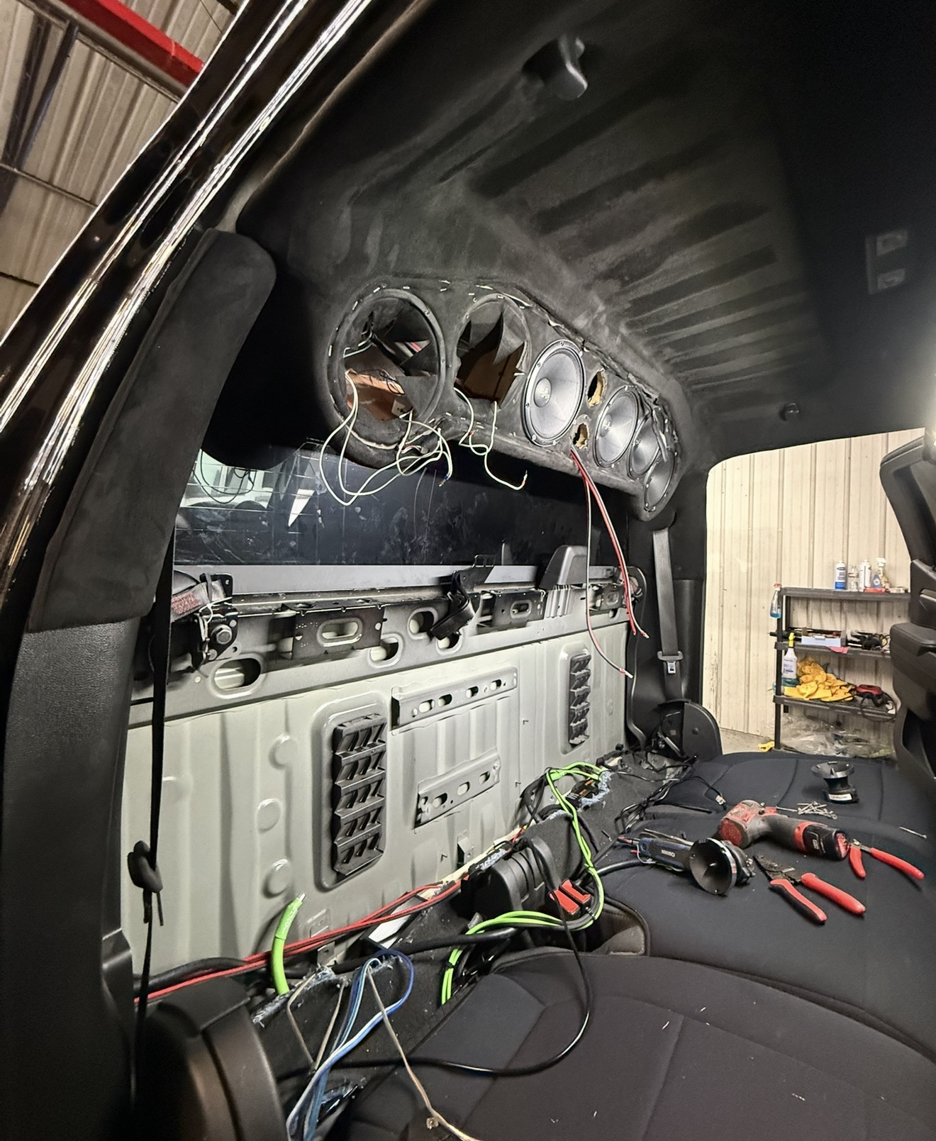 Truck overhead rack mid-build with loose wiring and unfinished speaker cutouts